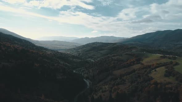 Winding Asphalt Road Between Hills with Forests and Meadows alt