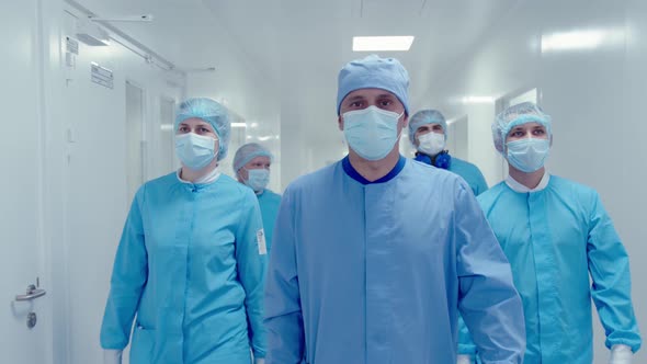 Slow Motion of Pharma Workers in Protective Masks and Medical Uniform Walking Indoors of