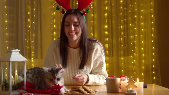 Woman Decorating Cat Red Christmas Bow