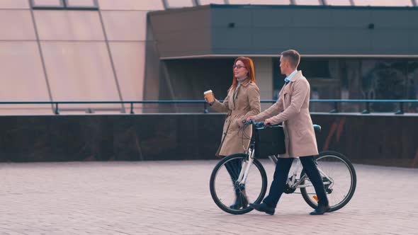 Businessman and woman chatting outside alt