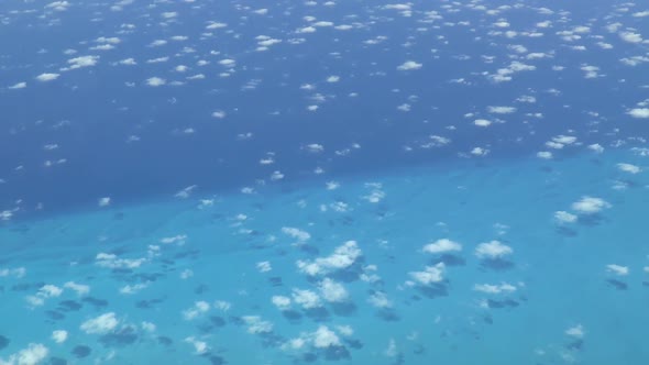 Aerial footage of the blue ocean around The Bahamas. Actual high altitude airplane cockpit view.