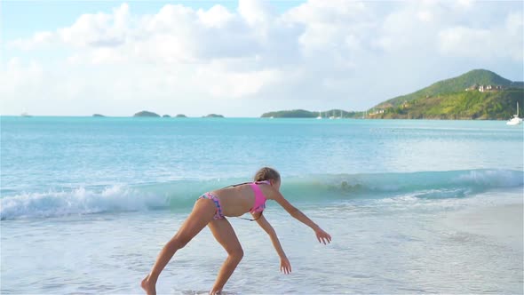 Little Active Girl Making Cartwheels on the Beach at Sunset alt