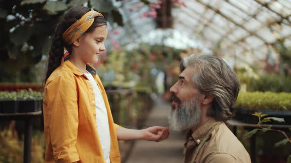 Lovely Girl and Granddad Talking and Smiling in Greenhouse Farm alt