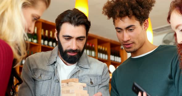 Group of fiends playing jenga 4k alt