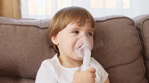 Little Girl Holding a Mask Nebulizer Inhaling Fumes Medication Into Lungs alt