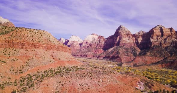 Wide aerial reveal of an epic mountain range and canyon below. alt