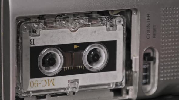 Audio Cassette in the Tape Recorder Playing and Rotates alt