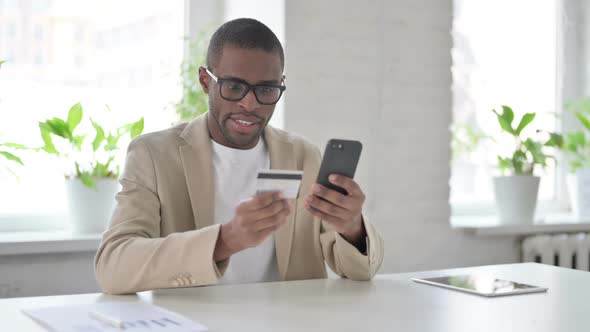 African Man Making Successful Online Payment on Smartphone alt