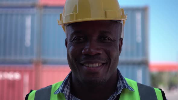 Portrait of happy worker smiling at camera, Factory worker man in hardhat at cargo container