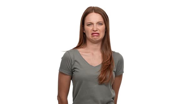 Portrait of Discontent Ginger Woman Twisting Mouth and Looking with Disgust and Aversion Isolated alt