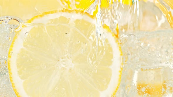 Super Slow Motion Shot of Pouring Water on Lemon Slices and Ice Cubes in Glass at 1000 Fps alt