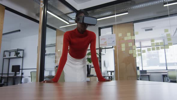 African american woman wearing vr headset at modern office alt