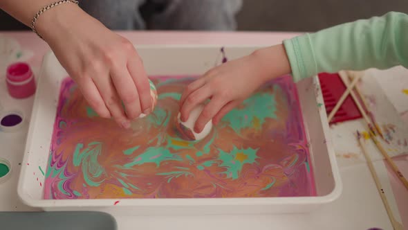 Woman and Girl Roll Eggs in Oily Water with Ebru Decor Mix alt