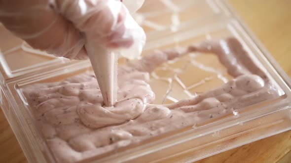 Woman preparing dessert, squeezing soft cream out of a pastry bag