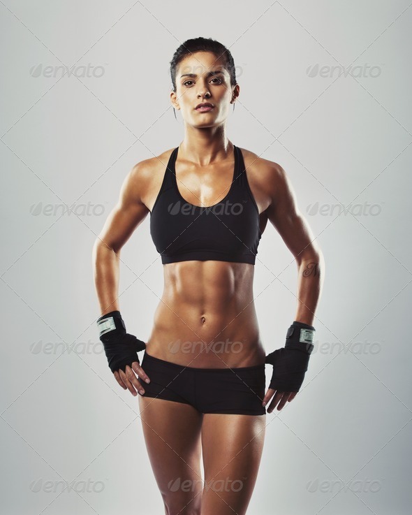 Fit and sexy young woman posing in grey background - Stock Photo - Images