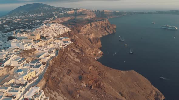flying over the cliff in Oia, Santorini - Greece at sunset