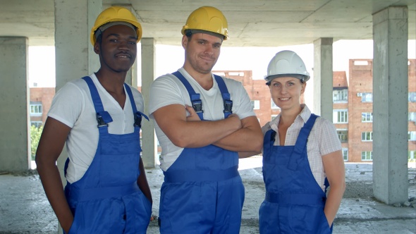 Confident diverse team of workmen and women standing grouped alt