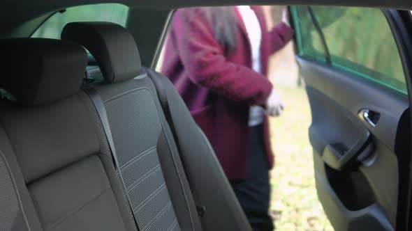 Attractive Woman Entering Taxi Car and Sitting Down on Passenger Seat