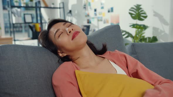 Beautiful Asia lady feel relax lay down on sofa with pillow at living room alt