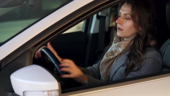 Woman is Angry and Upset on the Steering Wheel Because Her Car Broke Down alt