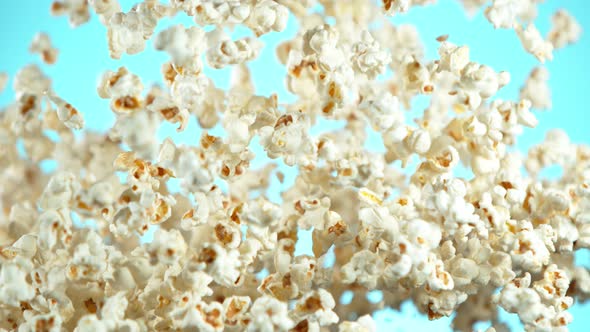 Super Slow Motion Shot of Popcorn on Blue Background After Being Exploded at 1000Fps alt