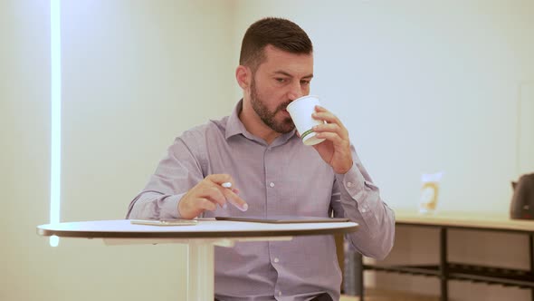 Young Businessman Working While Having a Coffee