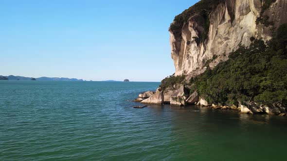 Epic cinematic flight next to the steep clifftops in New Zealand's Coromandel region. alt