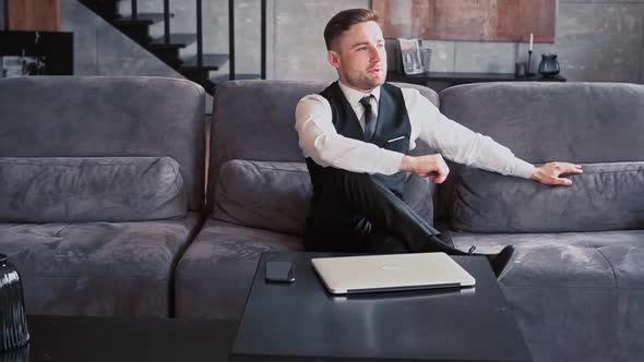 A Professional Sits in a Beautiful Dark Office in Front of a Laptop alt