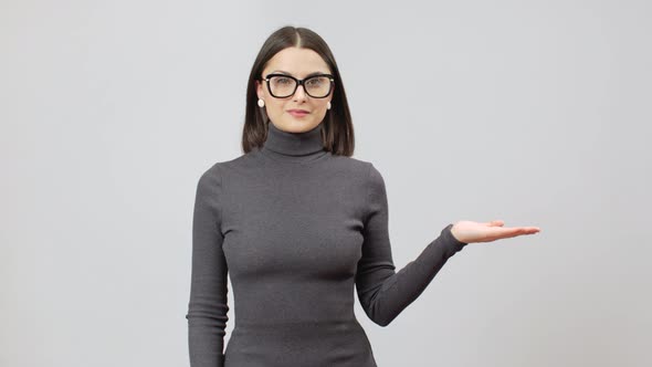 Woman In Gray Turtle Neck DressMaking Presentation Gesture, Copy Space On A Right Side