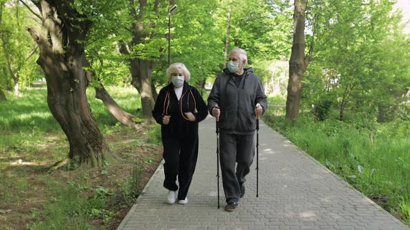 Active Senior Old Man, Woman Training Nordic Walking in Park During Quarantine alt