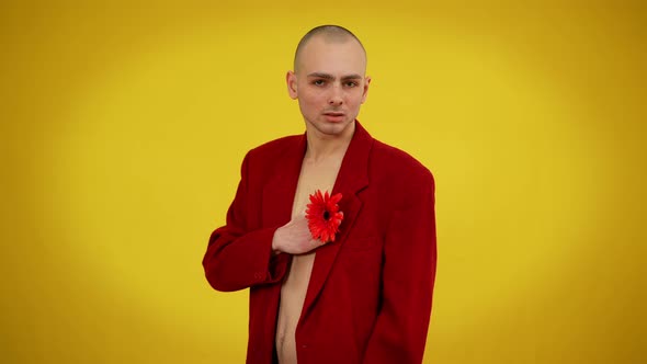 Charismatic Young Man in Jacket Posing with Red Flower at Yellow Background alt