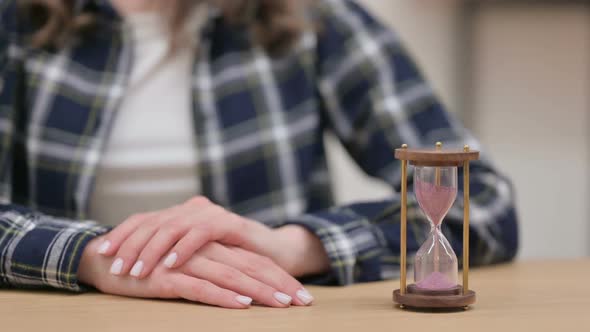 Hourglass Next to Female Hands Waiting Gesture Close Up alt