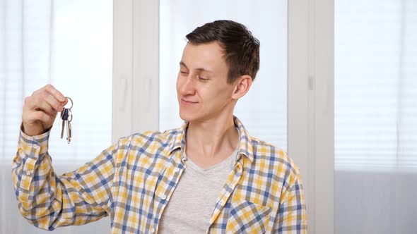 Man in Checkered Shirt Shakes Keys To New Apartment in Room alt