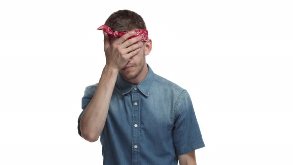 Young Exhausted Hipster Guy with Beard Red Bandana Wrapped Over Forehead Making Facepalm and Looking