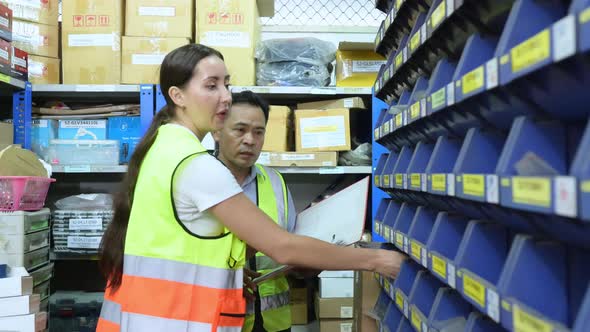 Warehouse Manager and female warehouse clerk counting the small parts stored alt