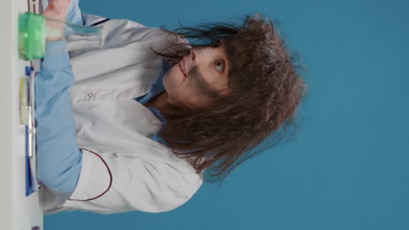 Vertical Video Insane Foolish Female Chemist Using Laptop and Beaker alt