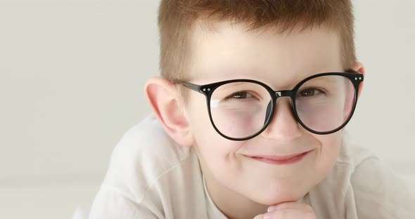 Portrait child boy With Glasses Looking at Camera. Laughs Happily toothless kid with Glasses Looking