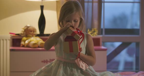 Door Opening and Surprised Caucasian Girl Opening Casket with Red Bow alt