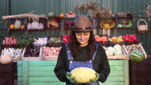 Woman Farmer (Seller) With Melon at the Farmer's Market.