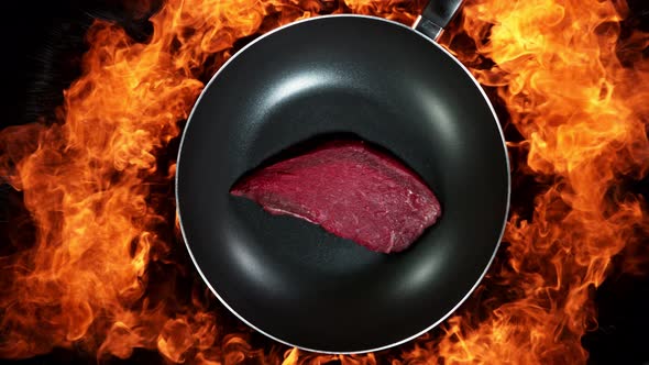 Super Slow Motion Shot of Throwing Beef Meat on Frying Pan and Fire Blast at 1000Fps alt
