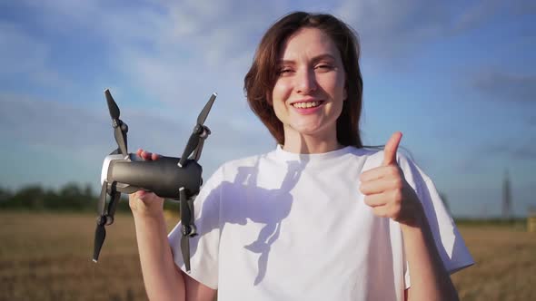 Permission To Fly a Drone. The Operator of the Quadcopter Shows the Like and the Drone, Smiling Girl