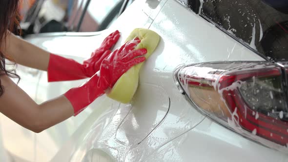 woman holding sponge to washing a car