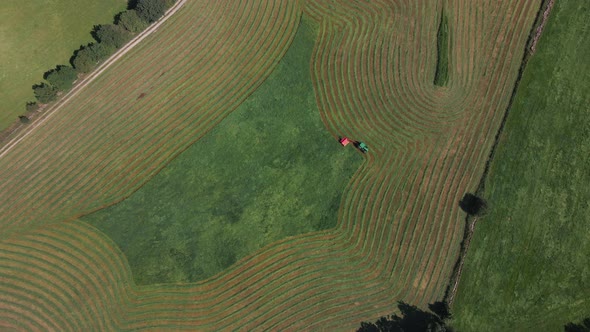 Bird's Eye View Of Tractor Pulling A Mower Through A Lush Green Field, Cutting Grass For Silage - dr alt