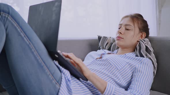 Female Lying on Sofa Using Computer