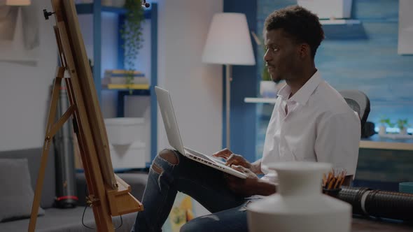 Black Young Artist Using Laptop Technology for Art Concept alt