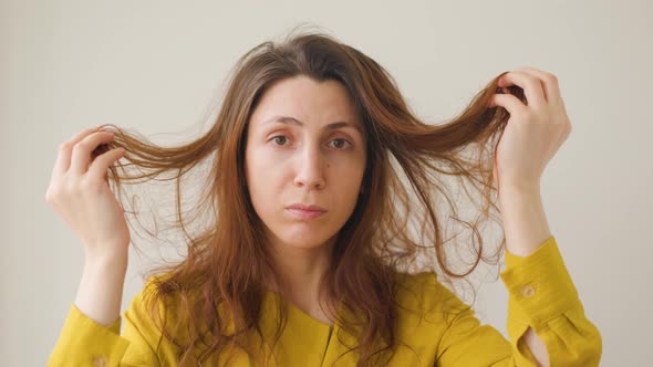 Portrait of Woman Holding Hands Long Hair and Looking Unhappy alt