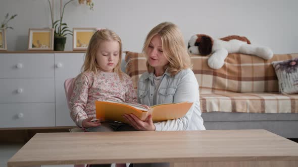 Motherhood Smiling Female Parent with Cute Beautiful Daughter Reading an Interesting Book While alt