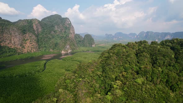 Drone flying over large mountains surrounded by rivers and mangroves in Ao Thalane Krabi Thailand on alt