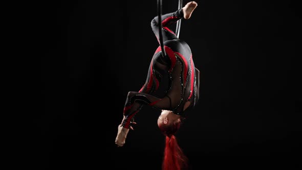 Wide Shot Flexible Young Woman Hanging on Air Hoop Upside Down Smiling and Looking at Camera alt