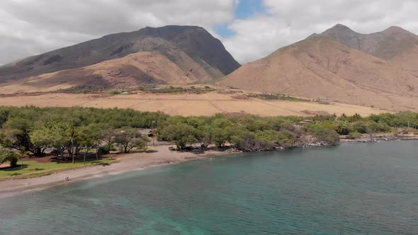 A drone shot flying toward Olowalu Beach park and the west Maui Mountains reveals a beautiful snorke alt